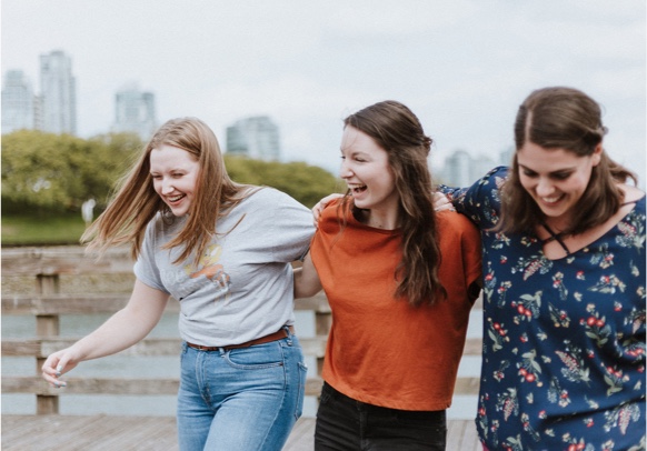 Friends laughing with arms around each other