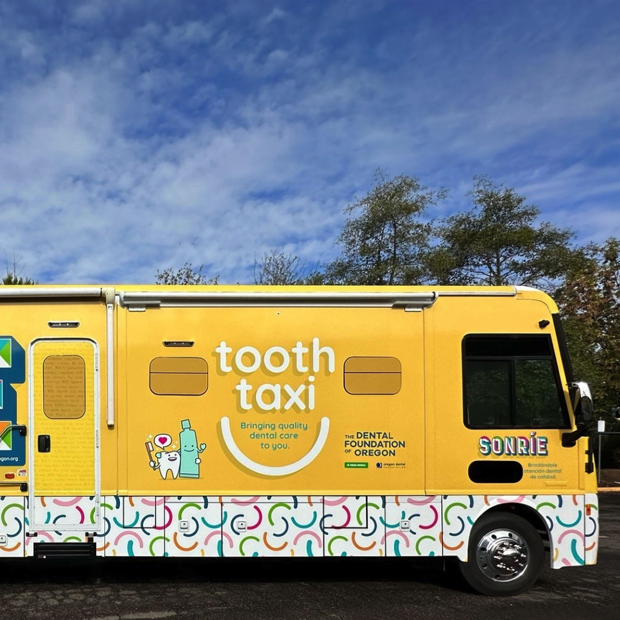 A yellow bus featuring a tooth taxi logo prominently displayed on its side.