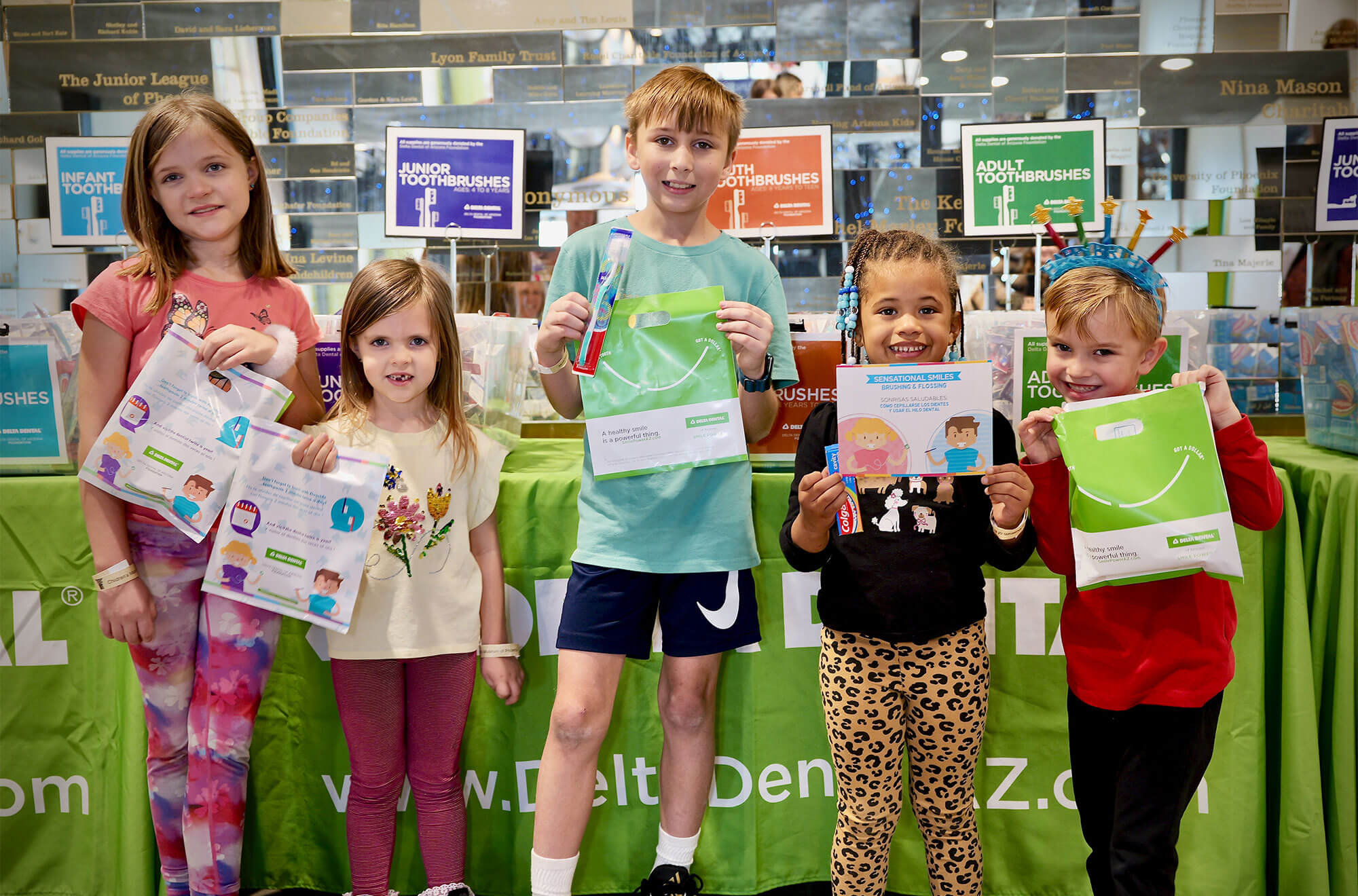 Children proudly display their certificates at a Delta Dental event, celebrating their achievements in dental health education.